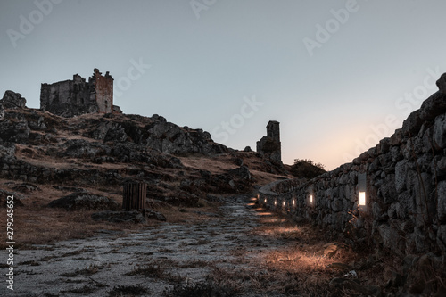 ruined castle at the top of the hill in a sunset