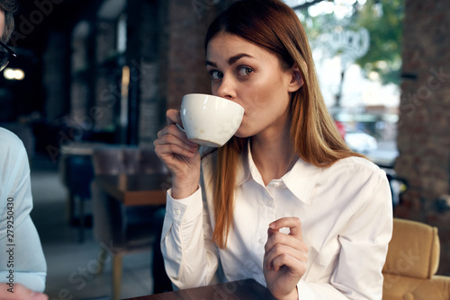 young woman with cup of coffee in cafe