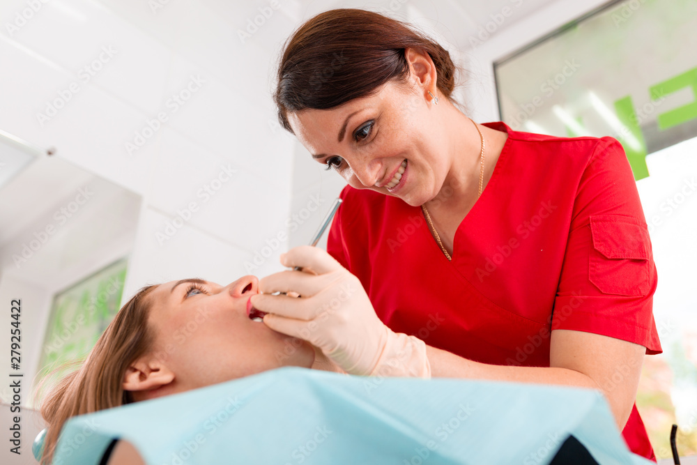 A female dentist checking her patient for caries. The girl will take care of the health of the teeth. Beautiful, healthy teeth, teeth care. A female dentist checking her patient for caries. The girl will take care of the health of the teeth. Beautiful, healthy teeth, teeth care.