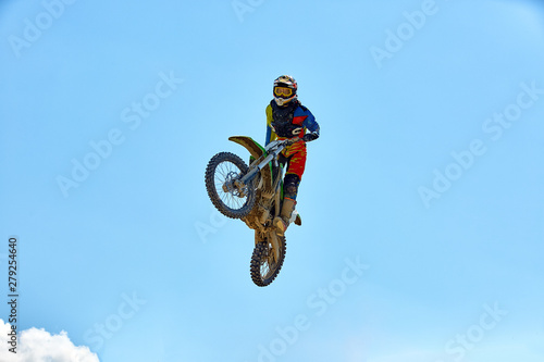 Biker does the trick and jumps in the air. Extreme concept, adrenaline. Copy space. Sky background