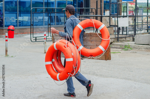 man carries in his hands a life buoy