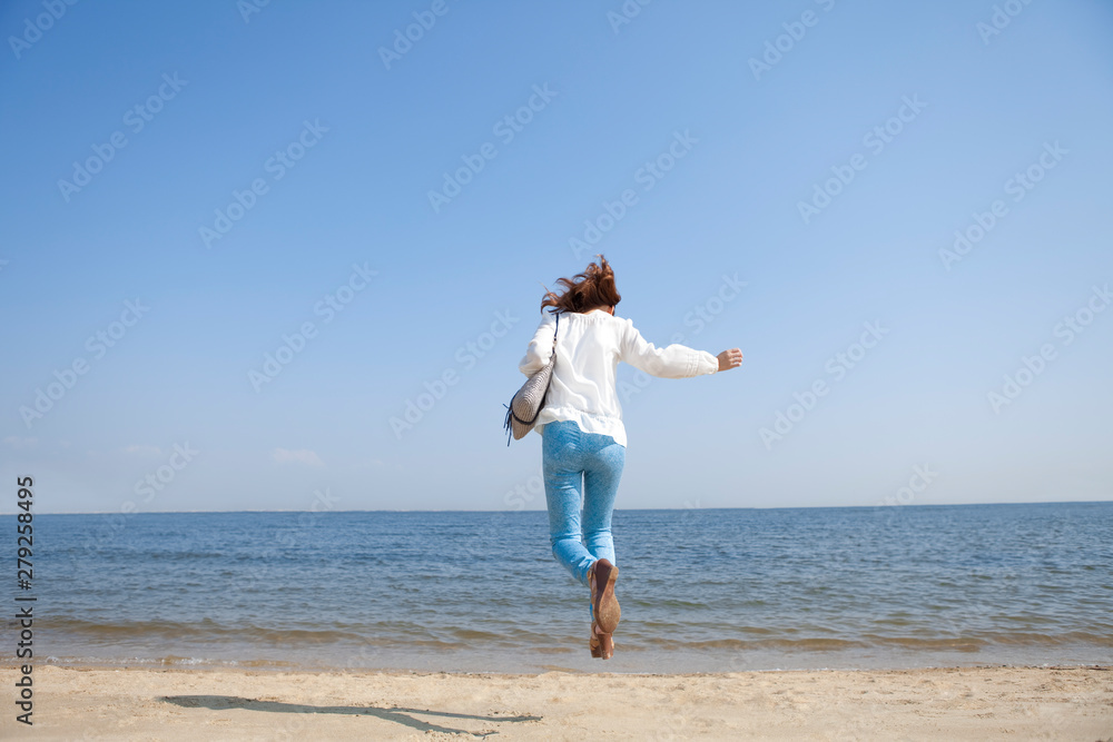 海辺でジャンプする女性