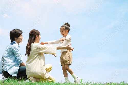 草原で遊ぶ家族3人