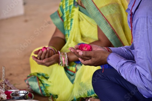 At the time of havan, sitting with flowers in hand