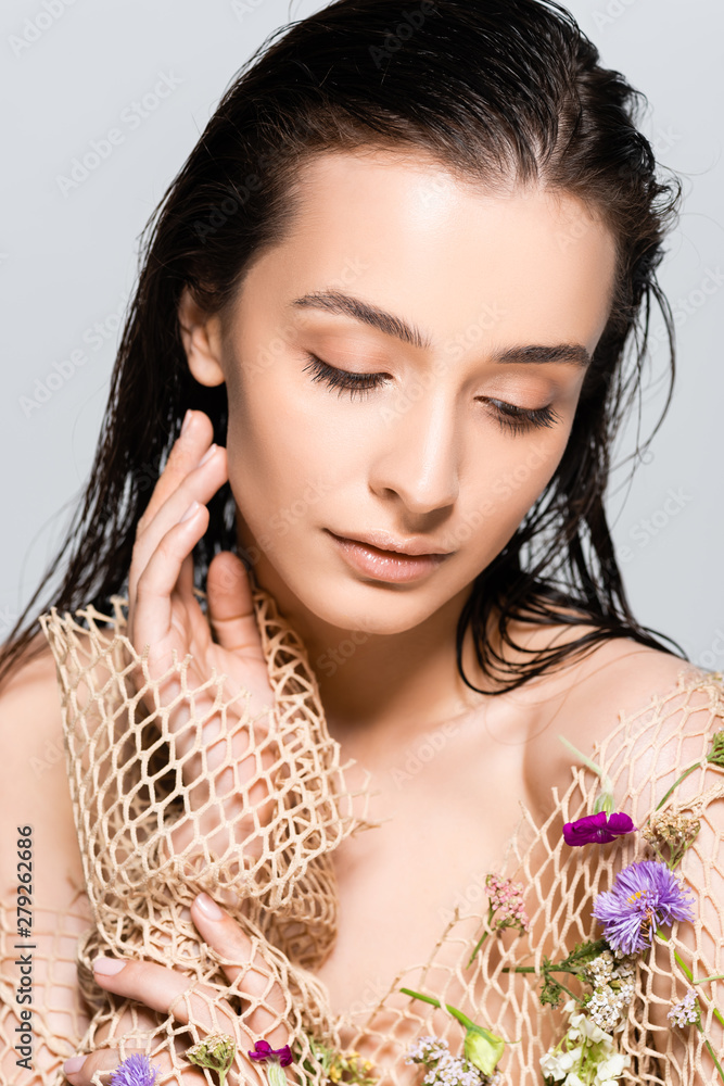 Φωτογραφία beautiful woman in mesh beige clothing with purple flowers isolated on grey