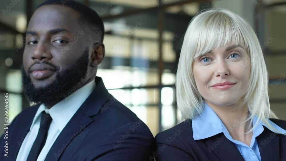 Afro-american man and caucasian woman standing as team, law firm offers services Afro-american man and caucasian woman standing as team, law firm offers services
