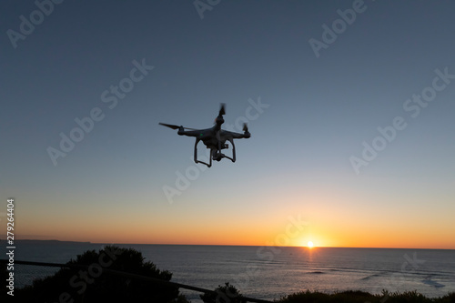 Professional or Prosumer Drone flying over the sea at Sunrise