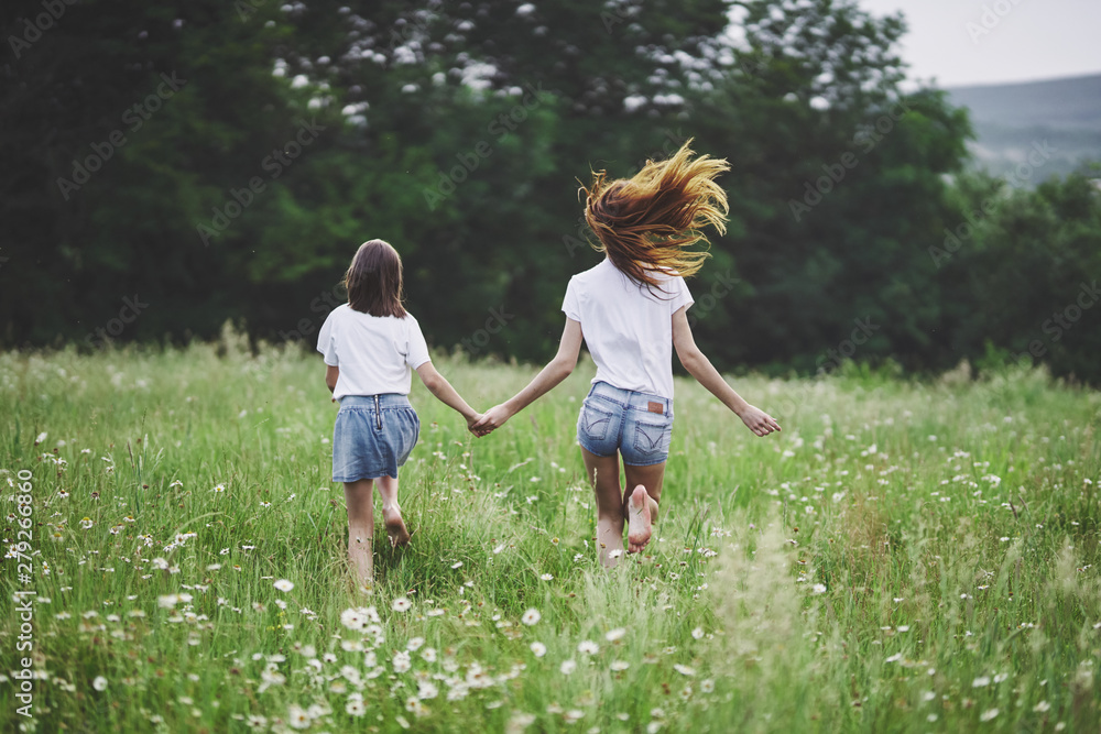mother and daughter running on the meadow