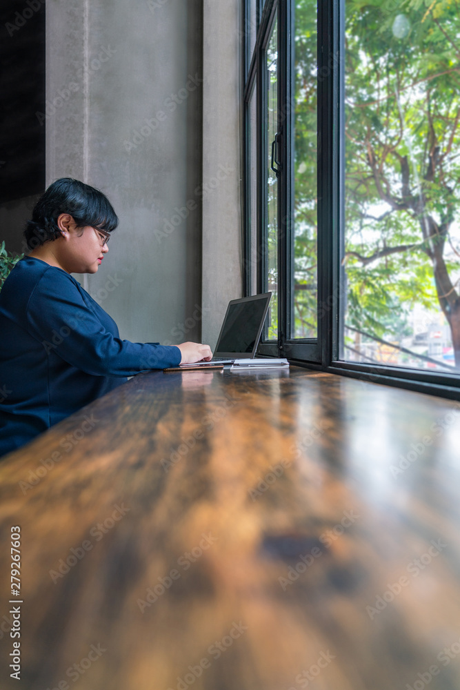 Fototapeta premium Asian student using laptop at rustic garden view coffee
