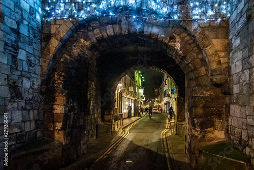 YORK, ENGLAND, DECEMBER 11, 2018: People walking in the beautiful medieval streets of city of York, United Kingdom, surrounded by the old city wall