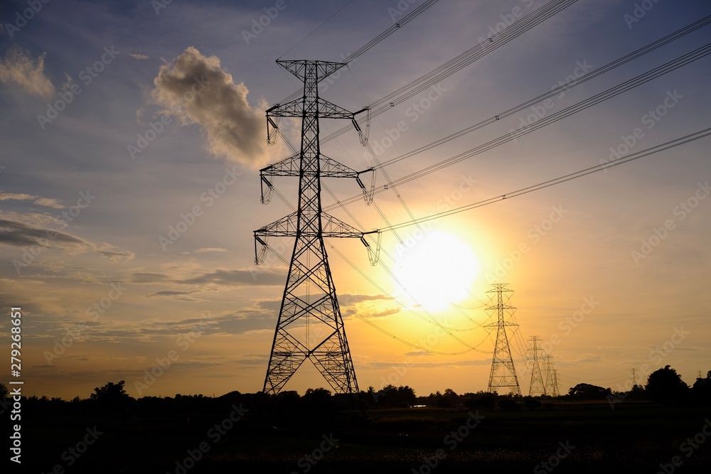 High voltage electricity pole, Electricity plant landscape over sunset and rice field. Part of high-voltage substation with switches and disconnectors.