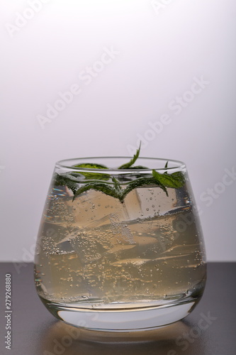 Refreshing drink with gas bubbles. Nalit in a transparent glass. It laid crushed ice. Decorated with mint leaves.