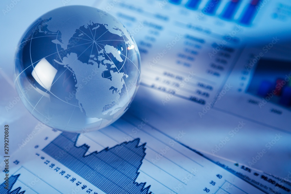 Glass Globe On Financial Reports Close-up Glass Globe On Financial Reports Close-up