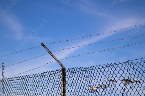 Barbed wired mesh fence providing security to farmland in rural Hampshire
