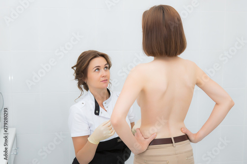 Woman plastic surgeon examines the patient chest