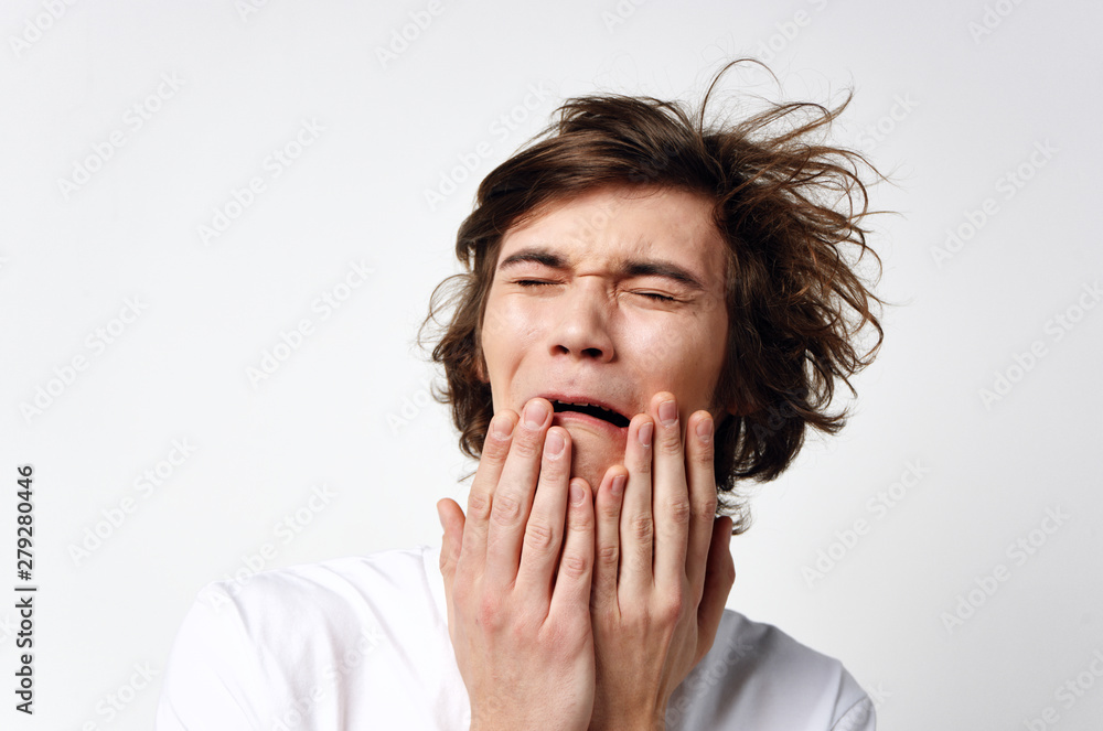 young man covering mouth with his hands young man covering mouth with his hands