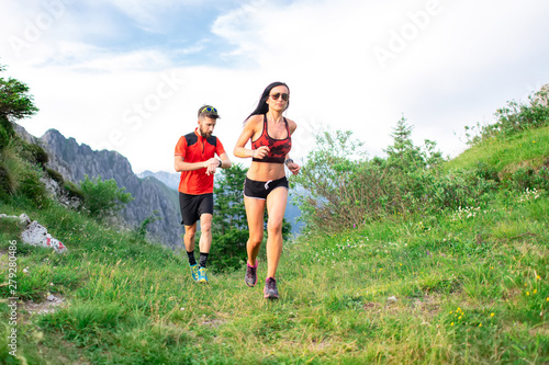 Athletic trainer measures the time of an athlete female race woman in the mountain
