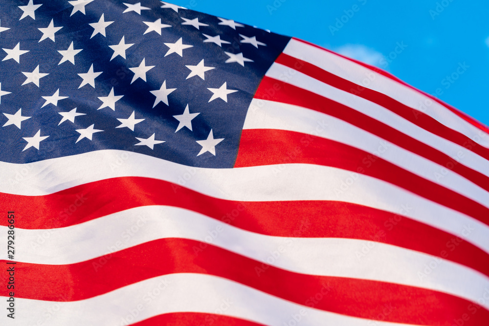 American flag waving in the wind against blue sky American flag waving in the wind against blue sky