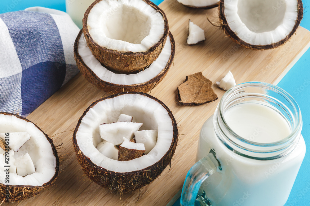 Coconut pieces on wooden board on blue background Coconut pieces on wooden board on blue background