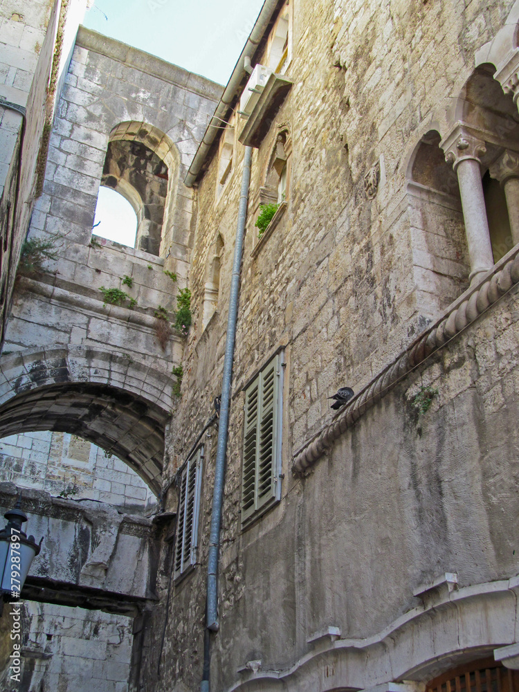 Old building in the old town square of Split, Croatia. Ancient architecture of a downtown near the Diocletian’s palace is popular tourist destination. View look up.