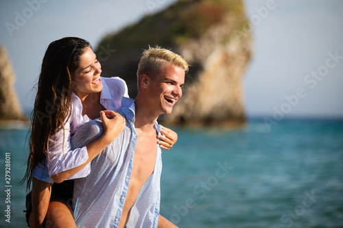 Happy young couple having fun and love at beach on sunny day
