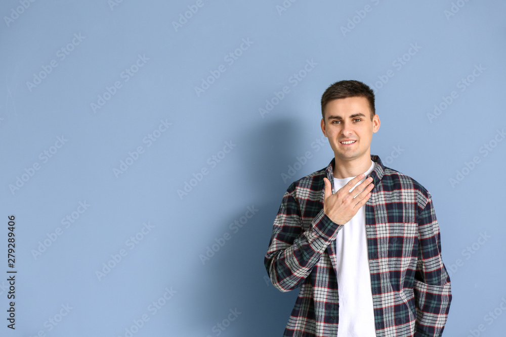 Young deaf mute man using sign language on grey background Young deaf mute man using sign language on grey background
