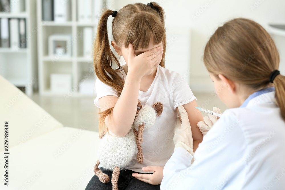 Doctor vaccinating little girl in clinic Doctor vaccinating little girl in clinic
