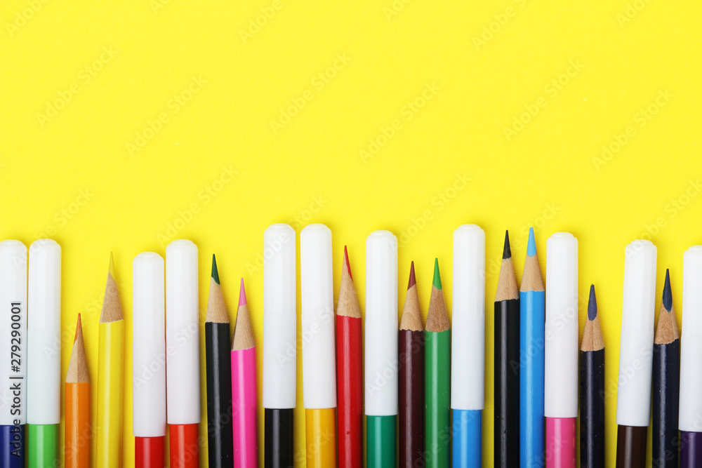 Multicolored markers and pencils at bright background	