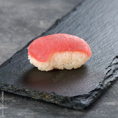 tuna nigiri sushi on a black dish from low angle