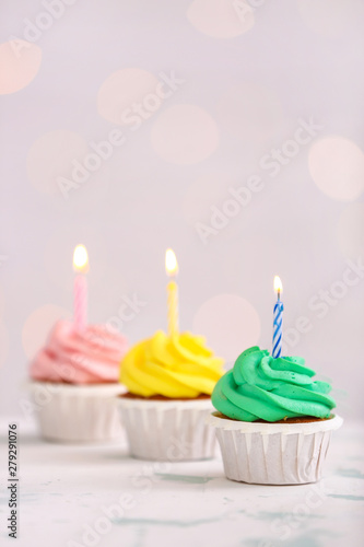 Assortment of tasty Birthday cupcakes against defocused lights