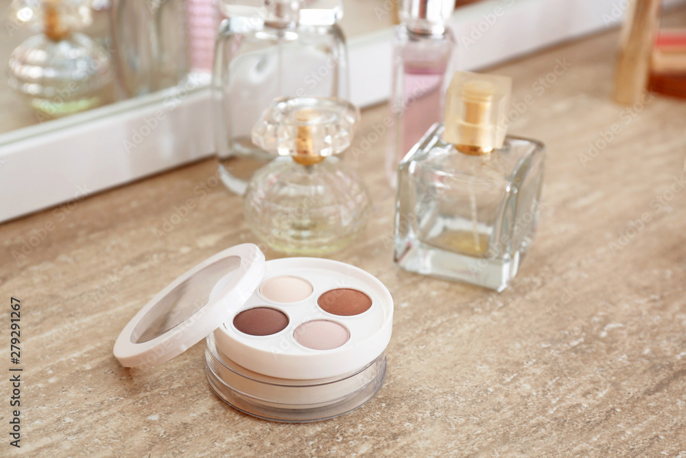 Makeup cosmetics with bottles of perfumes on dressing table Makeup cosmetics with bottles of perfumes on dressing table