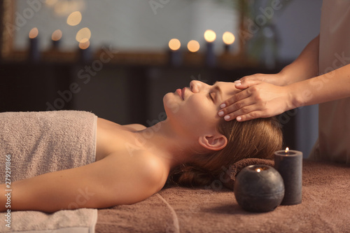 Beautiful young woman receiving facial massage in spa salon photo