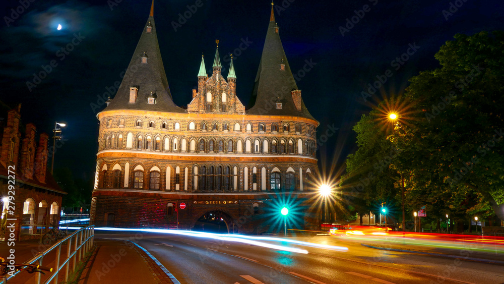 The famous Holsten Gate at night with traffic blur in the City of Lubeck, Germany