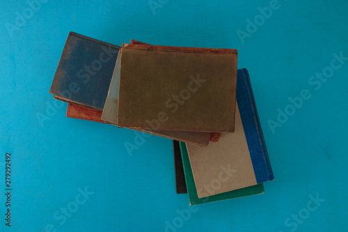 Old books on a blue-green wooden. Top view.