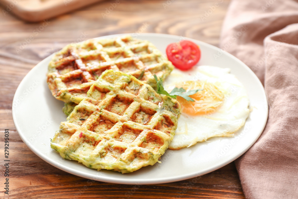 Plate with tasty squash waffles and fried egg on wooden table Plate with tasty squash waffles and fried egg on wooden table