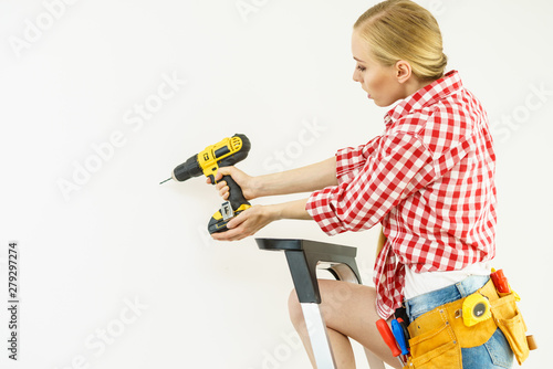 Woman drilling in wall
