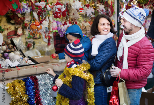 Smiling parents with children buying decorations