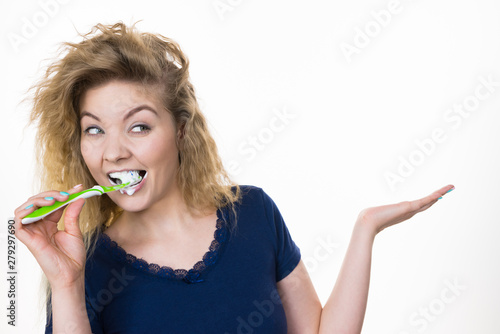 Woman brushing teeth holds open hand