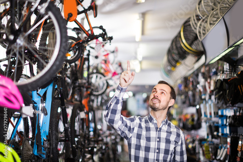 Racer is choosing in sports store convenient bike
