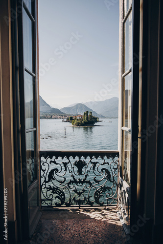 Fototapeta Piękny widok z balkonowego okna przy Lago Maggiore i Borromean wyspami w pogodnym świetle, bada Włochy. Zabytki starej architektury w Stresie. Letnie wakacje w Europie