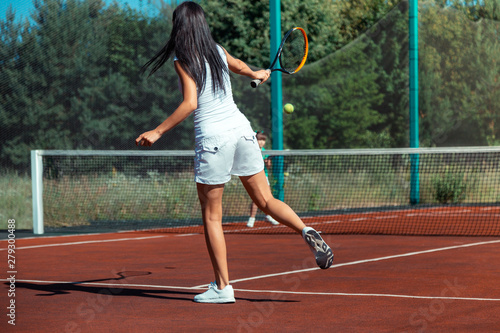 Fit mommy wearing white shorts playing tennis with daughter © Viacheslav Yakobchuk