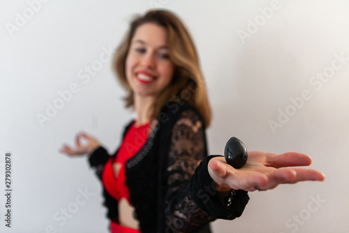 Beautiful girl holds nephrite egg. A gorgeous young woman holds a jade egg in the palm of her hand, sacred object believed to have many health benefits in women.