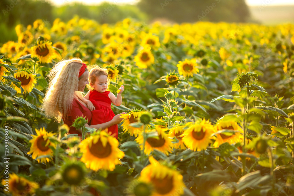 Happy mother with the daughter in the field with sunflowers Happy mother with the daughter in the field with sunflowers