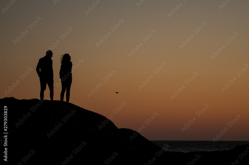 Fototapeta premium Portret para sylwetki patrząc oceanu na tle słońca