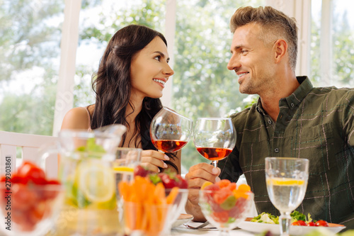 Couple clanging their glasses with wine enjoying lunch together