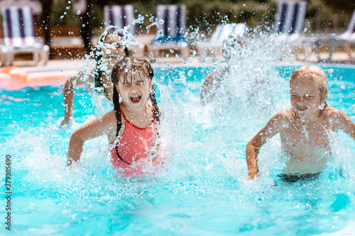 Children laughing while splashing water in swimming pool © Viacheslav Yakobchuk