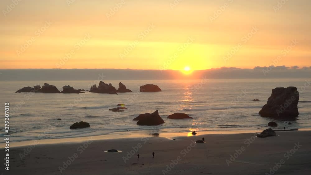 Sunset over Bandon Oregon beach with Cat and Kittens rock formation silhouetted, zooming in Sunset over Bandon Oregon beach with Cat and Kittens rock formation silhouetted, zooming in