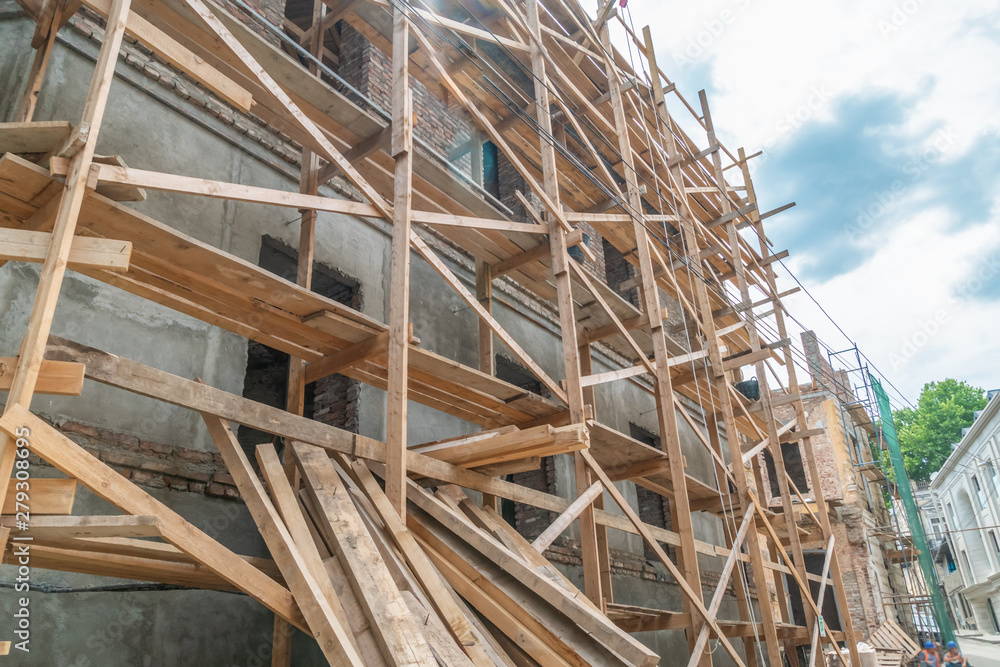 Home construction. Wooden scaffolding on a building close up