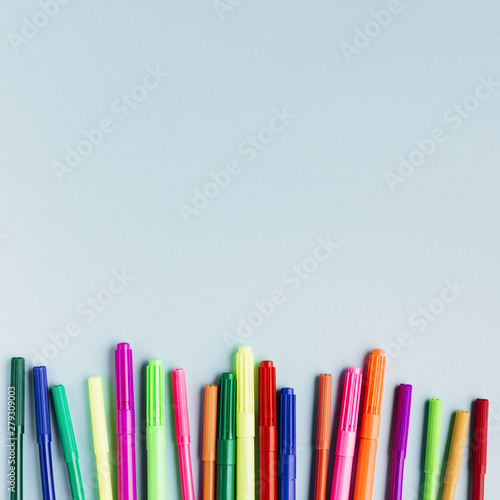 Multicolored markers on blue table