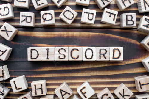 Foto discord wooden cubes with letters, disagreement mistrust concept, around the cub